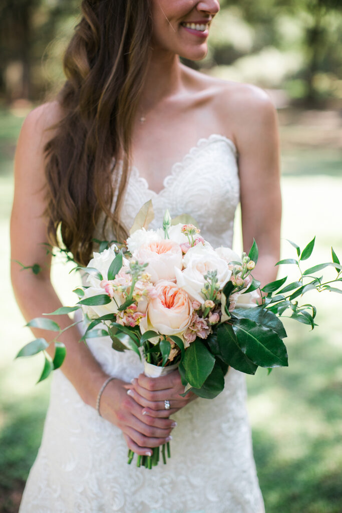 Bride holds her bouquet in Airlie Gardens before her wedding in Wilmington NC.