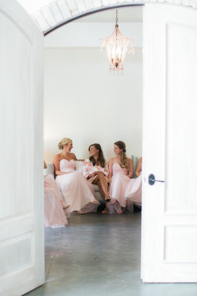 Inside Wrightsville Manor in Wilmington NC a brides and her bridesmaids take a minute to relax before the wedding begins.