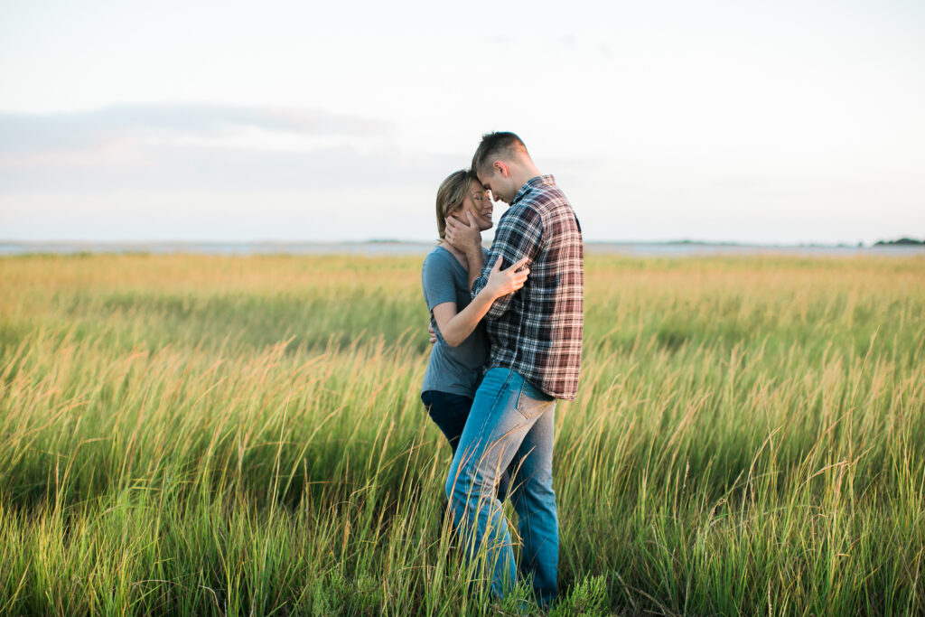 Engaged couple taking engagement photos at Fort Fisher NC at sunset.