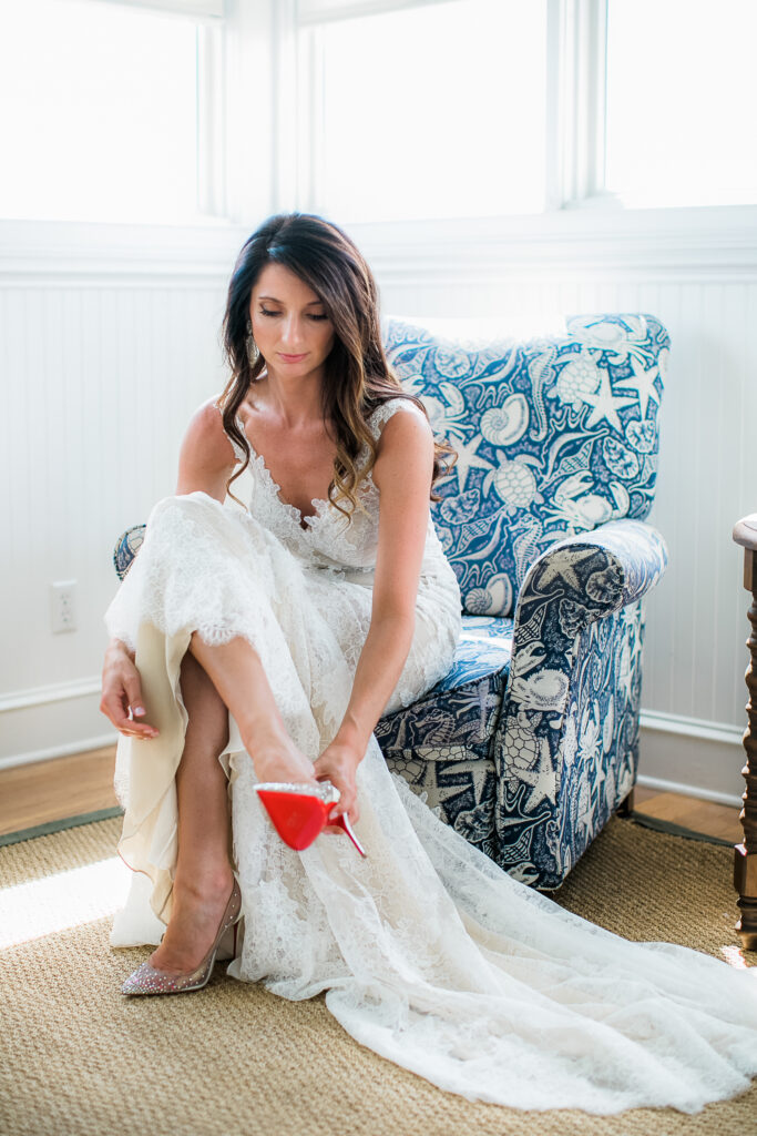 A bride getting ready on Bald Head Island puts her shoes on before walking down the aisle to her wedding.