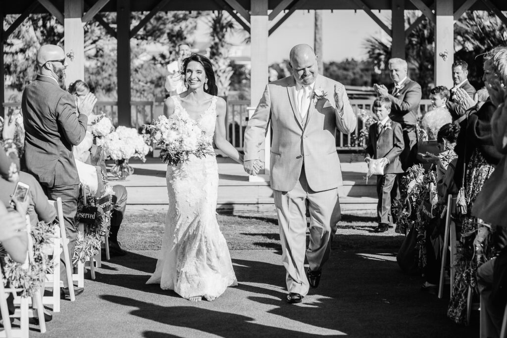 Excited groom walks his new bride down the aisle during their BHI Club wedding.