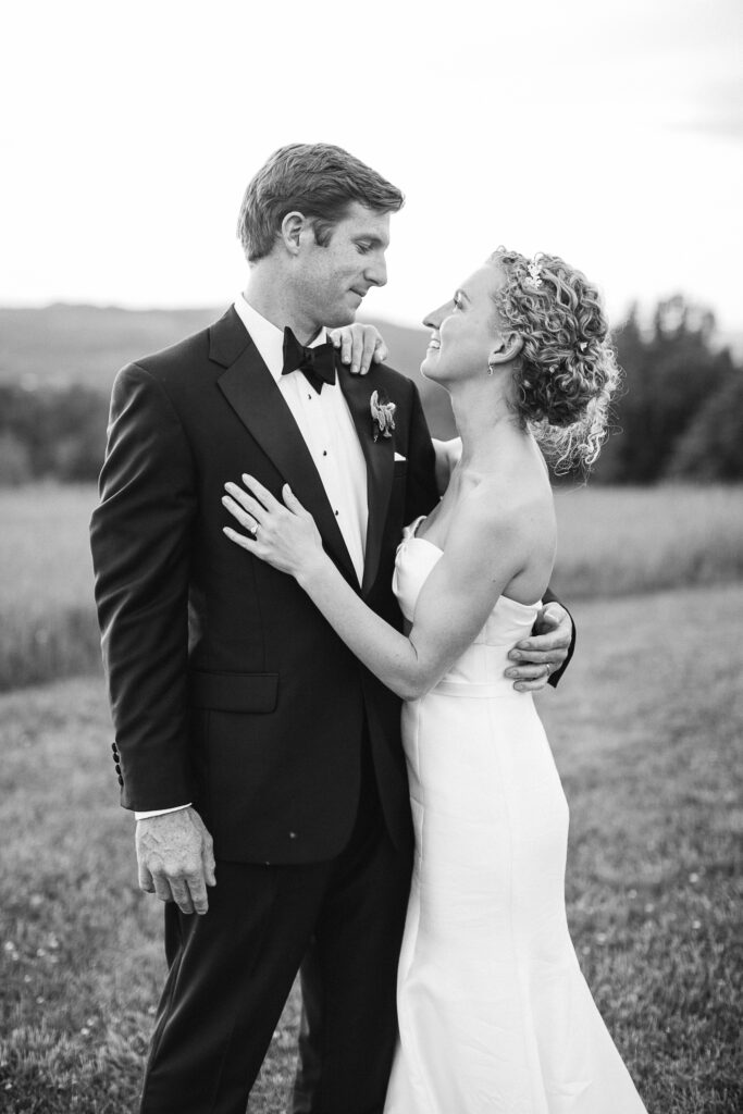 Bride looks lovingly at her husband after their Vermont farm wedding.