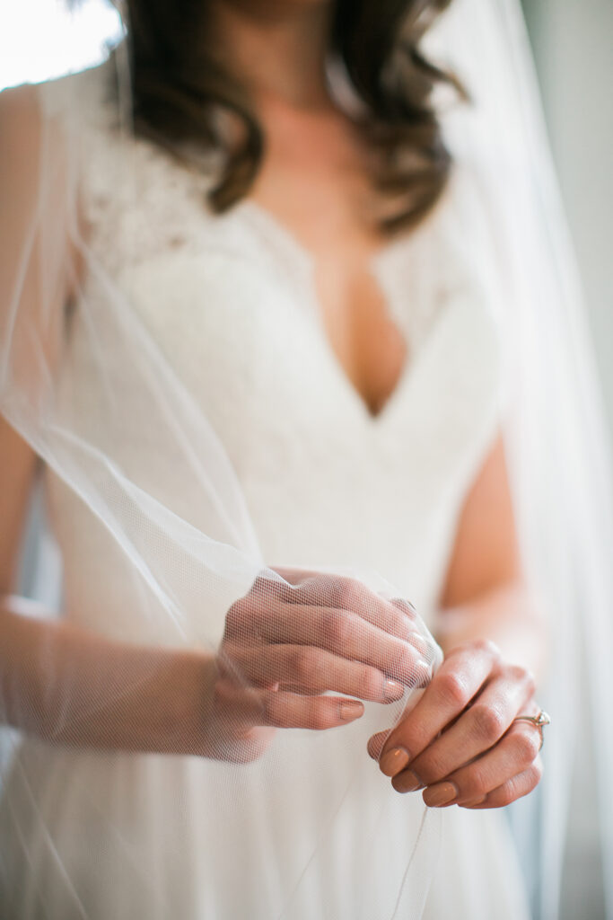 Bride holds veil during her wedding.