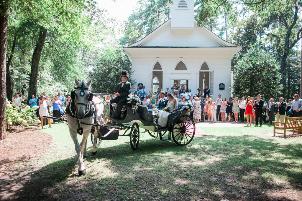 Bride and groom leave their Airlie Gardens wedding by Horse Drawn Carriage.