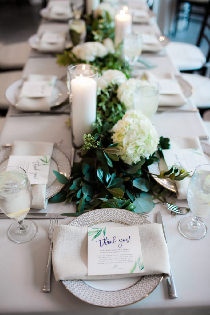 Green and white and beige place settings at wedding reception in Wilmington NC.