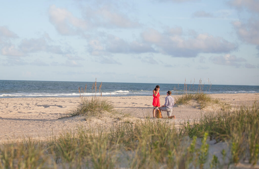 Man proposes to his girlfriend on Wrightsville Beach with beautiful engagement ring. 