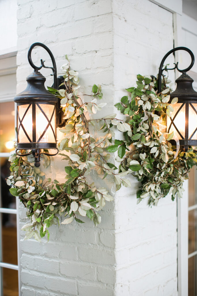 Greenery details hang on lamps outside wedding venue in Wilmington NC.