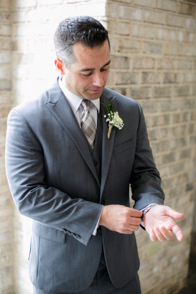 Groom fixes his cuff links at a Wrightsville Manor wedding in Wilmington NC.