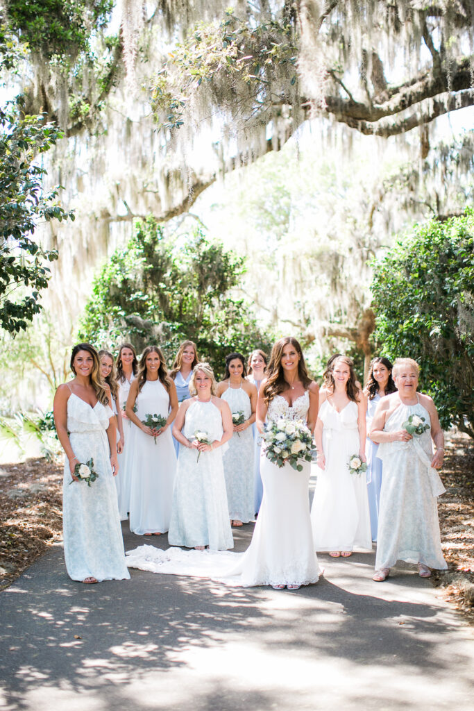 A bride and her bridesmaids walk down one of the many lush pathways inside Airlie Gardens.