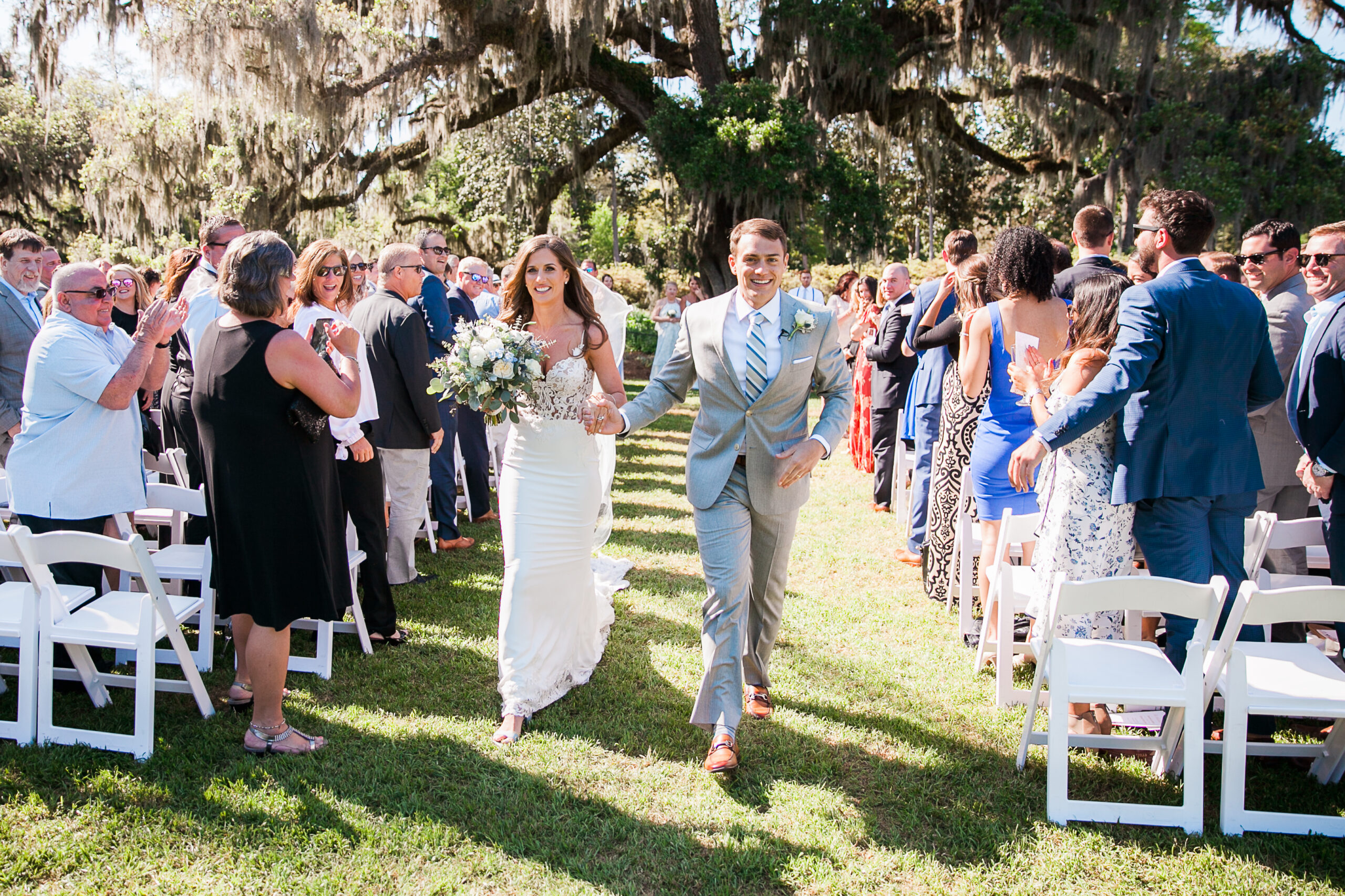 A couple walks down the aisle after their Airlie Gardens wedding ceremony.