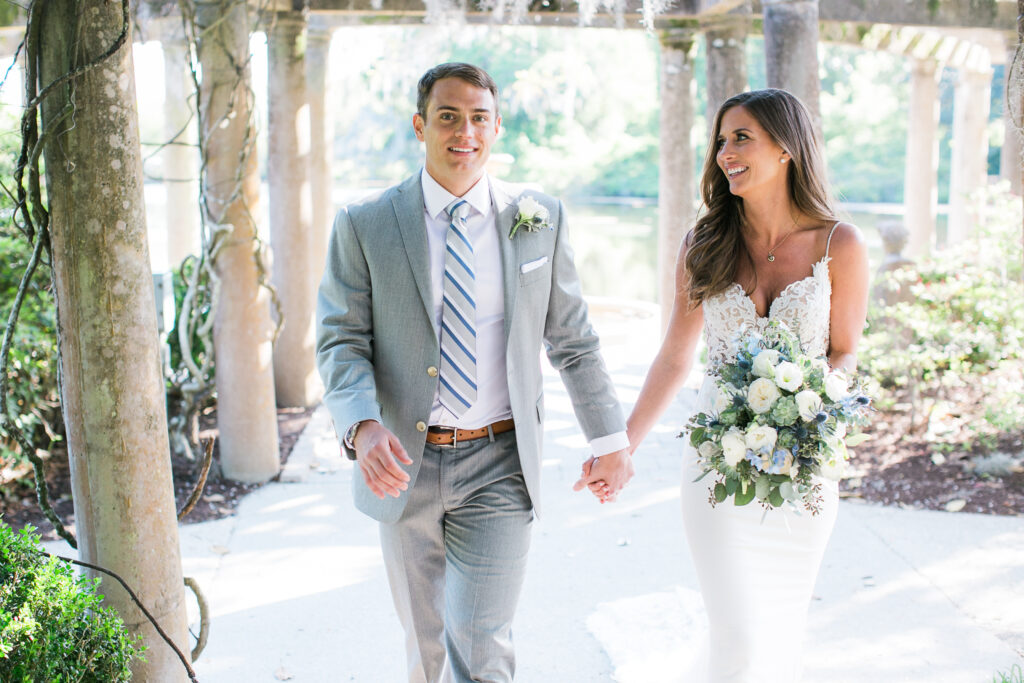 A bride and groom walk through one of airlie gardens many natural paths on their wedding day.