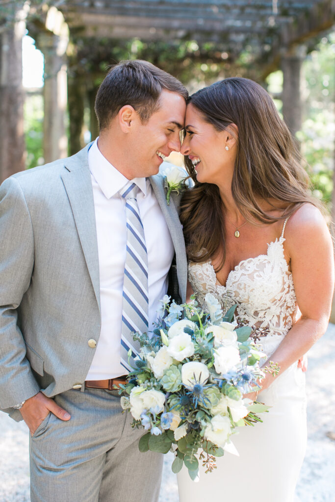 A bride and groom share a sweet moment after their wedding in Airlie Gardens.