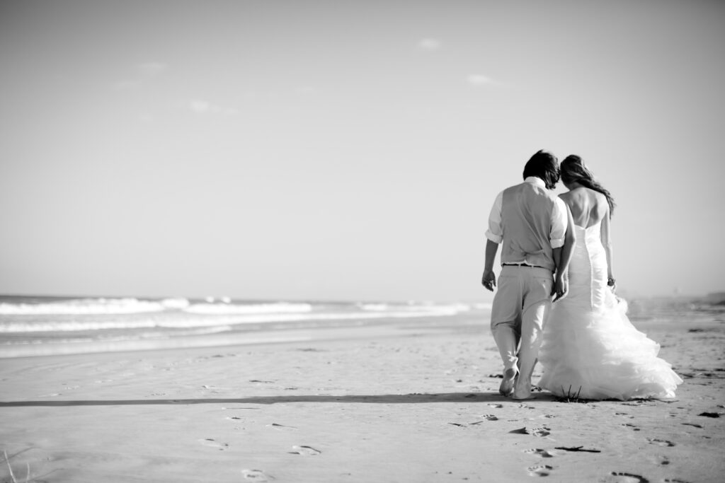 Bride and groom walk on Wrightsville Beach after their Shell Island Resort wedding.